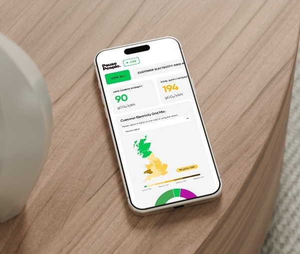Mobile phone on a table, displaying Utilita's Live Carbon Dashboard, representing the future of carbon reporting.