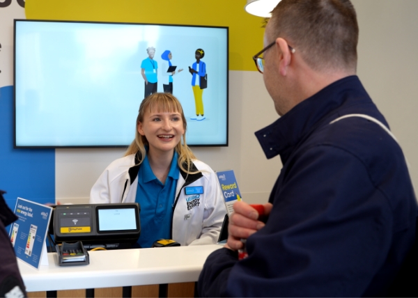 Energy Expert talking with a customer in a Utilita Energy Hub, offering face-to-face energy-saving advice on the high street.